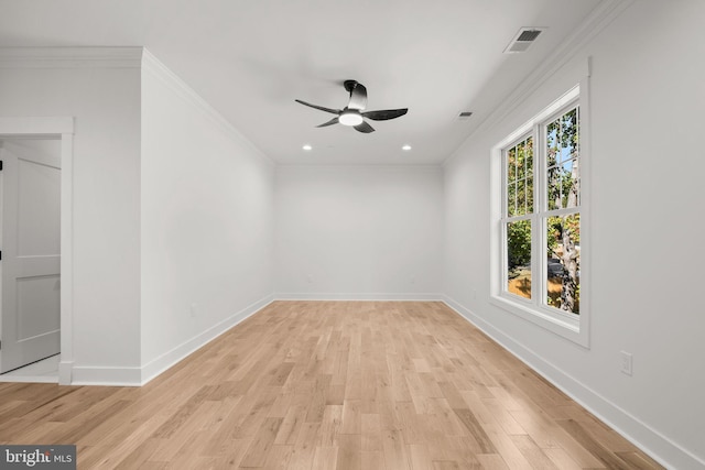 unfurnished room featuring light wood-type flooring, visible vents, baseboards, and ornamental molding