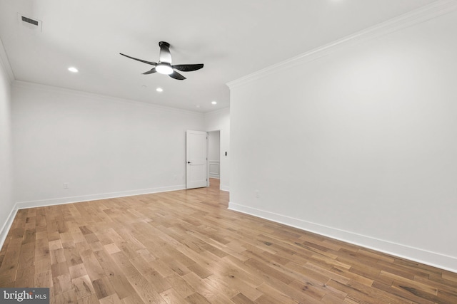 empty room featuring crown molding, visible vents, light wood-type flooring, and baseboards