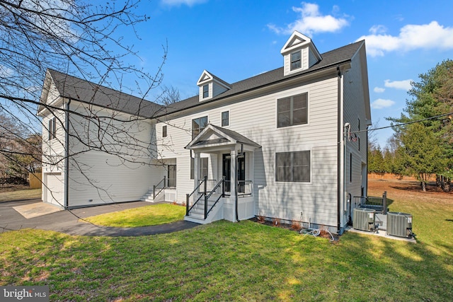 view of front of property featuring a garage, central AC unit, and a front yard