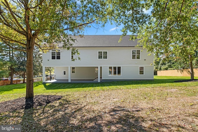 rear view of house with a patio area, fence, and a lawn