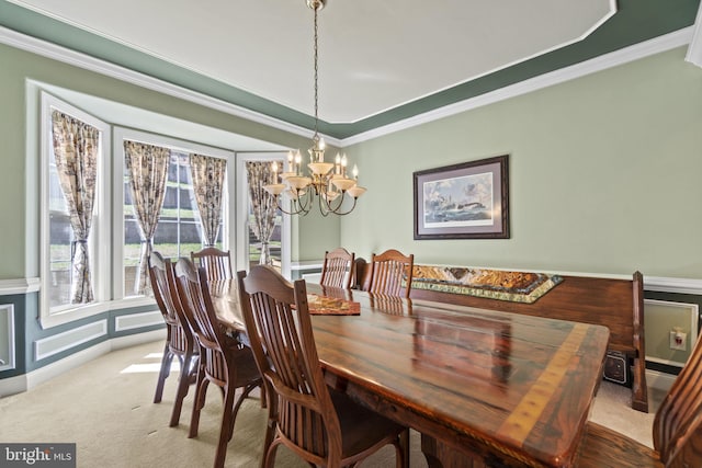 carpeted dining space featuring a notable chandelier and ornamental molding