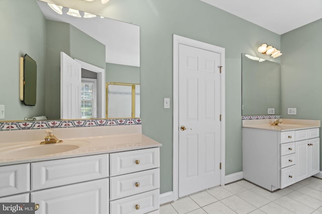 full bath featuring tile patterned flooring, two vanities, baseboards, and a sink