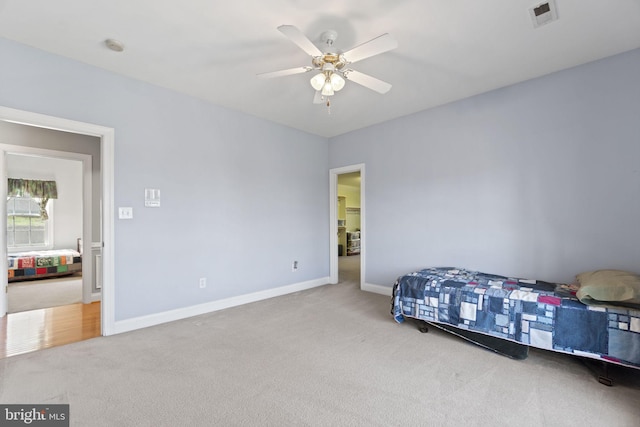 carpeted bedroom featuring visible vents, baseboards, and ceiling fan