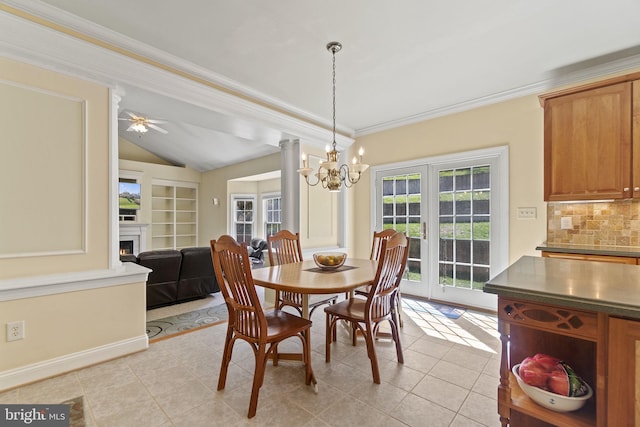 dining space with a warm lit fireplace, an inviting chandelier, crown molding, light tile patterned floors, and vaulted ceiling