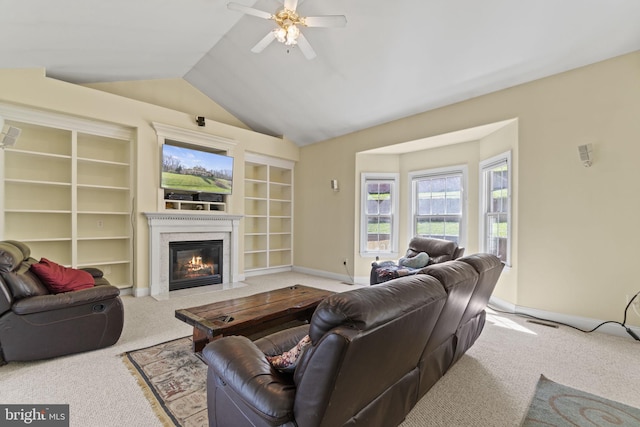 living room featuring a fireplace with flush hearth, lofted ceiling, carpet, baseboards, and ceiling fan