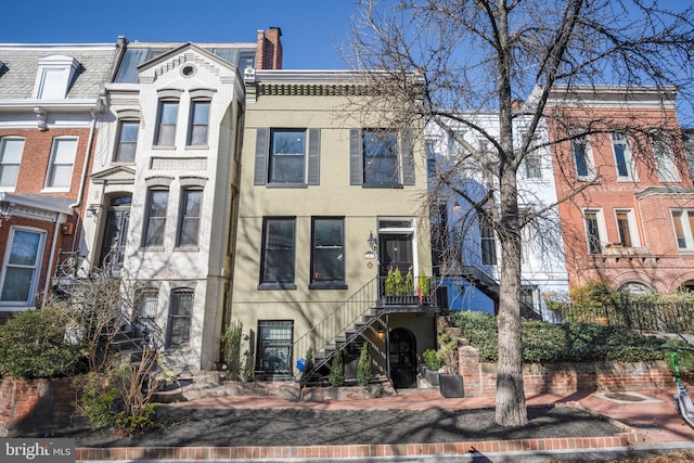 view of property with brick siding and stairway