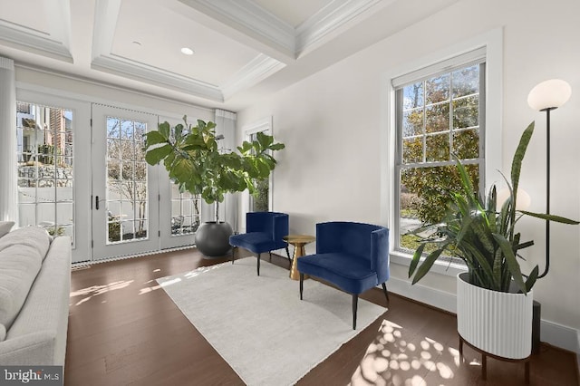 living area featuring beamed ceiling, coffered ceiling, crown molding, and wood finished floors