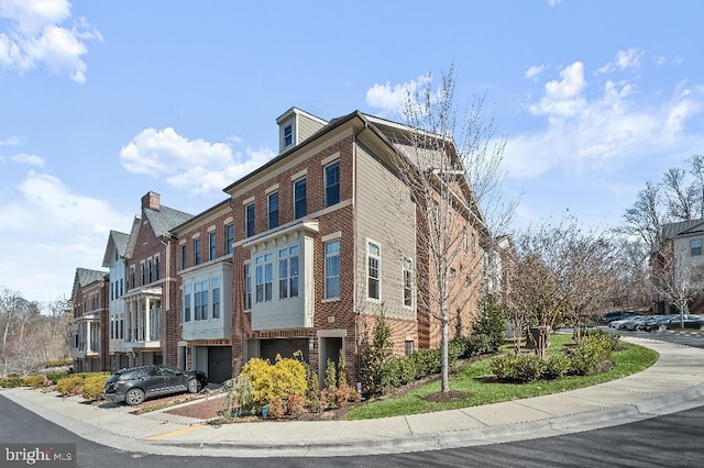 view of side of property with a garage and brick siding