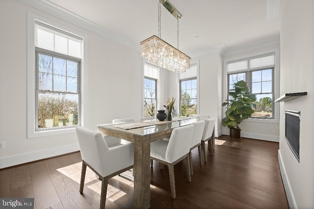 dining room featuring an inviting chandelier, crown molding, dark wood-style floors, and baseboards