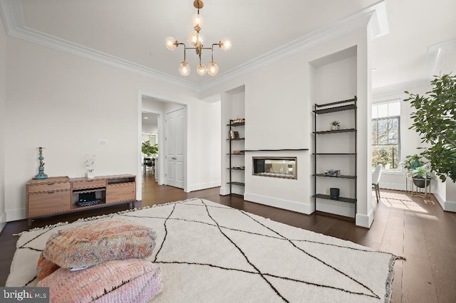 living area with dark wood-style floors, a glass covered fireplace, and ornamental molding