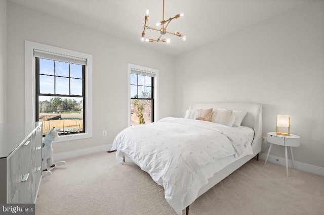 bedroom featuring a notable chandelier, multiple windows, and light colored carpet