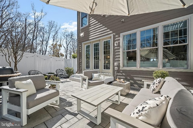 view of patio / terrace featuring an outdoor living space with a fire pit and fence