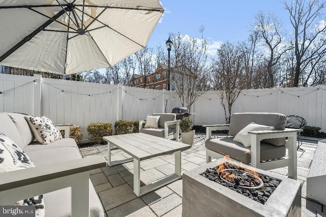 view of patio with an outdoor living space with a fire pit and a fenced backyard