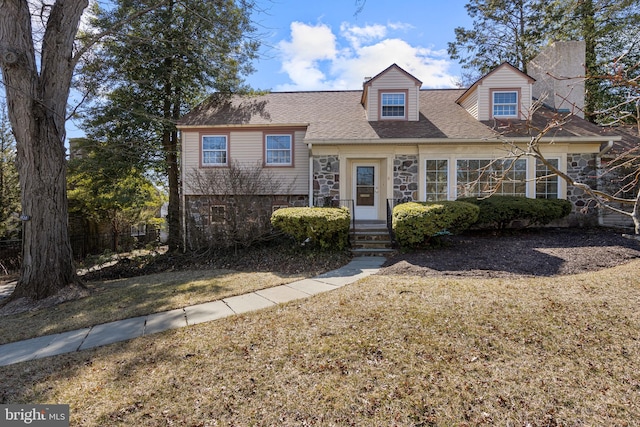 view of front facade featuring stone siding and roof with shingles