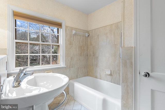 bathroom with a sink, shower / bath combination, a healthy amount of sunlight, and tile patterned flooring