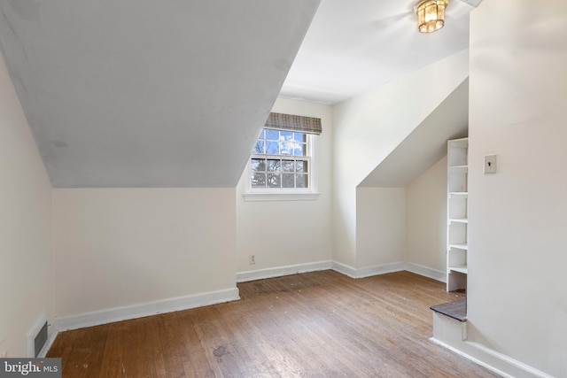 bonus room featuring visible vents, lofted ceiling, baseboards, and wood-type flooring