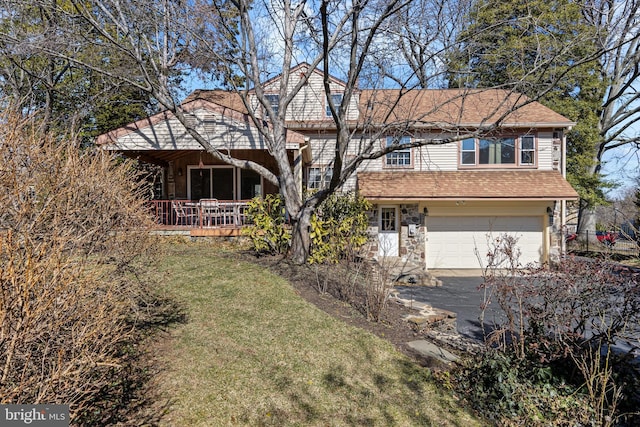 view of front facade with aphalt driveway, stone siding, a shingled roof, an attached garage, and a front yard