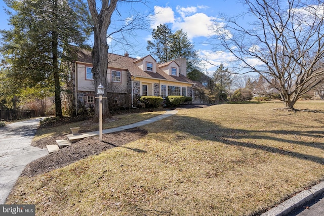 view of front of property featuring stone siding and a front lawn