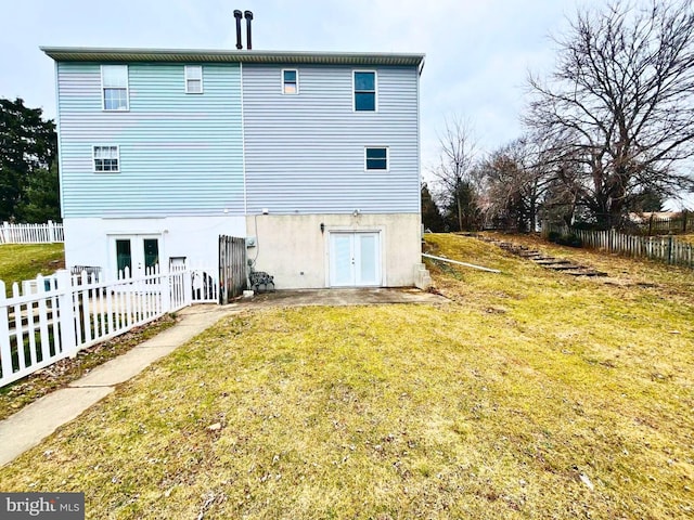 rear view of property featuring french doors, a yard, and fence