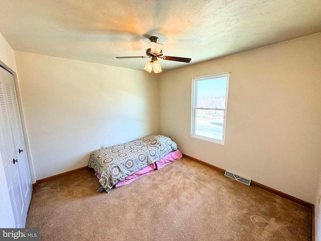 bedroom featuring a closet, visible vents, carpet flooring, and baseboards