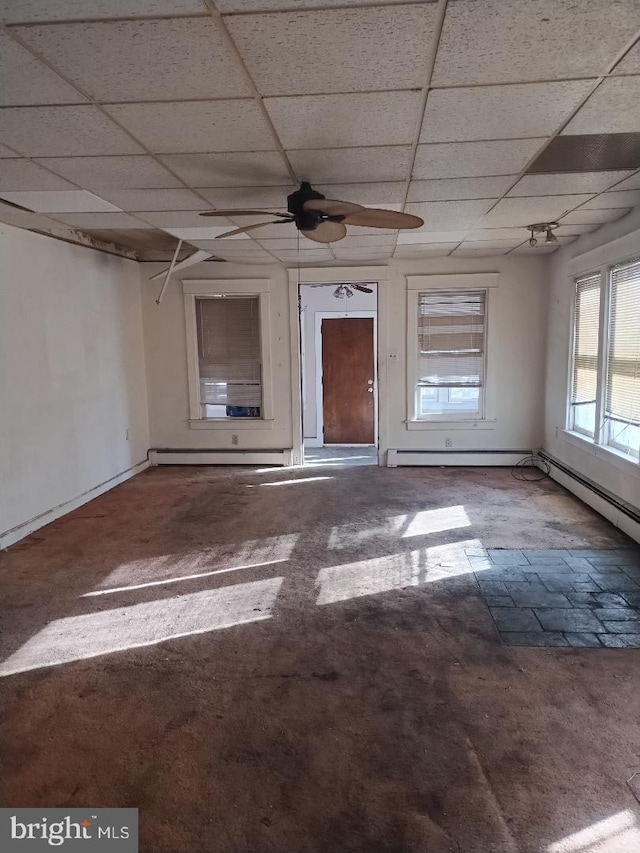 unfurnished room featuring a paneled ceiling, ceiling fan, and a baseboard radiator