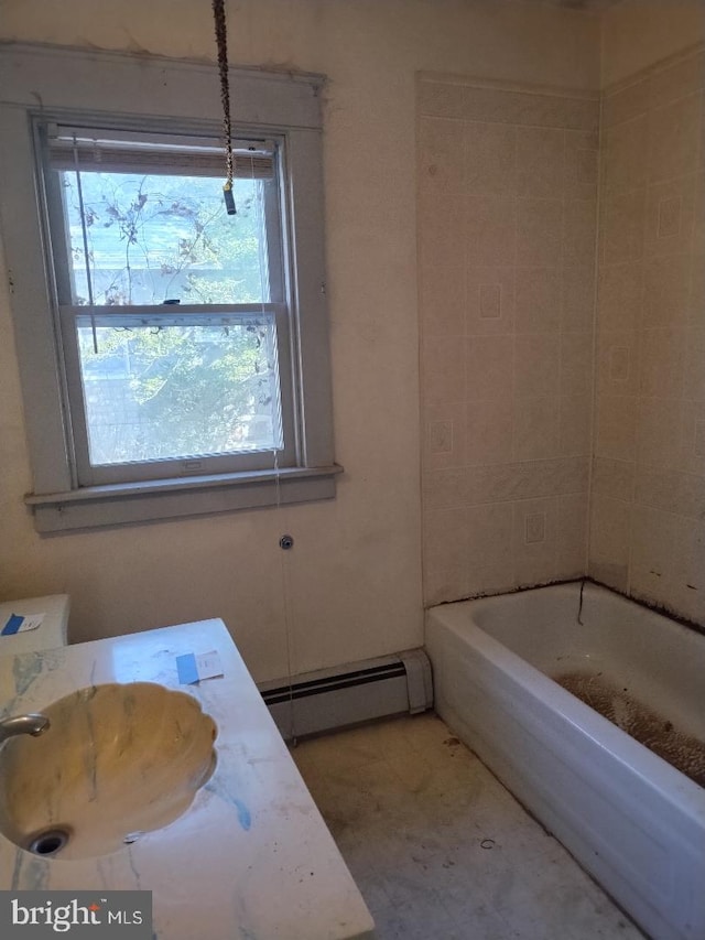 full bath with a baseboard heating unit, tile patterned floors, and a sink