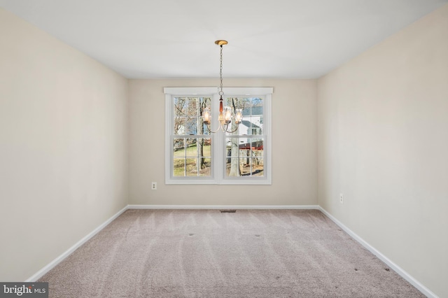 unfurnished dining area featuring a notable chandelier, carpet flooring, visible vents, and baseboards