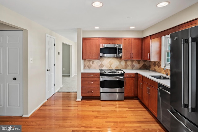 kitchen featuring a sink, stainless steel appliances, backsplash, and light countertops