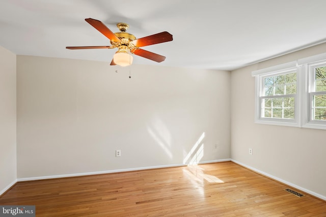 empty room featuring visible vents, wood-type flooring, baseboards, and ceiling fan