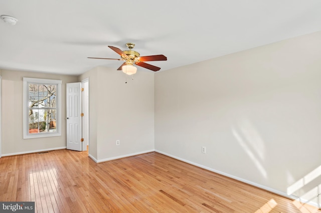 spare room featuring visible vents, baseboards, light wood finished floors, and ceiling fan