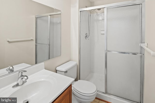 bathroom with toilet, a stall shower, and vanity