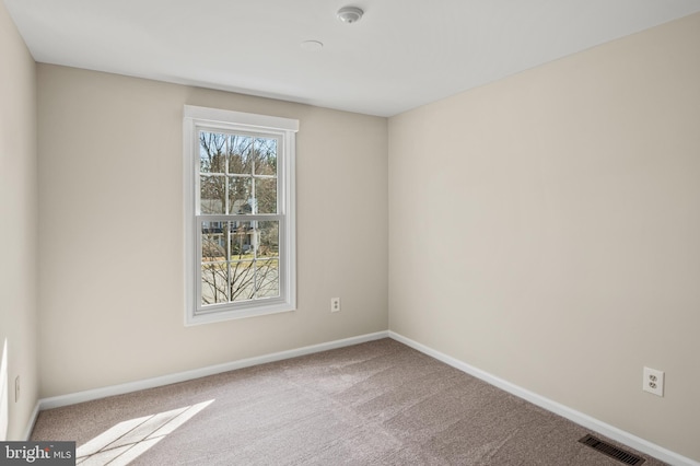 spare room with visible vents, carpet flooring, and baseboards