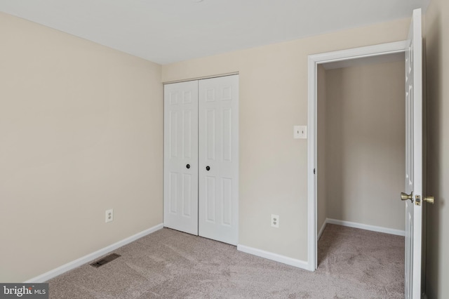 unfurnished bedroom featuring a closet, baseboards, visible vents, and carpet flooring