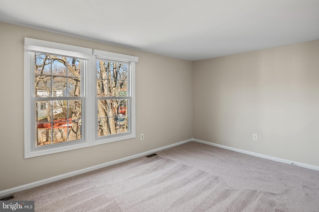 carpeted empty room with visible vents and baseboards