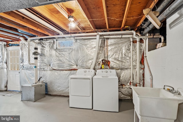 basement featuring separate washer and dryer and a sink