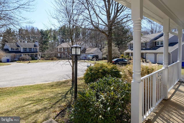 view of yard featuring a residential view and covered porch