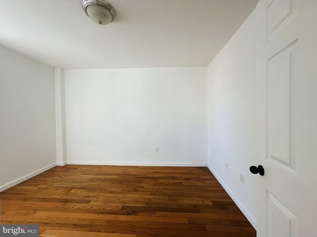 empty room featuring wood finished floors and baseboards