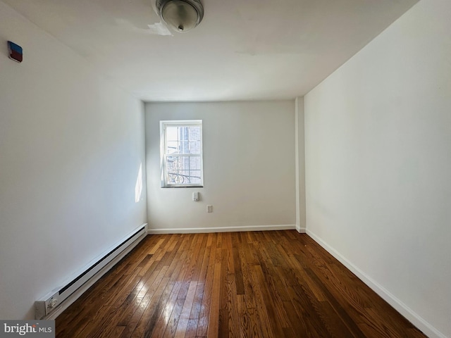 empty room with baseboard heating, baseboards, and hardwood / wood-style flooring