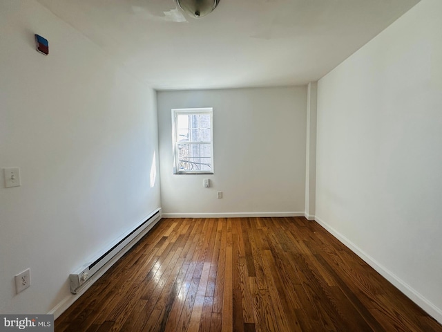 spare room with hardwood / wood-style floors, baseboards, and baseboard heating