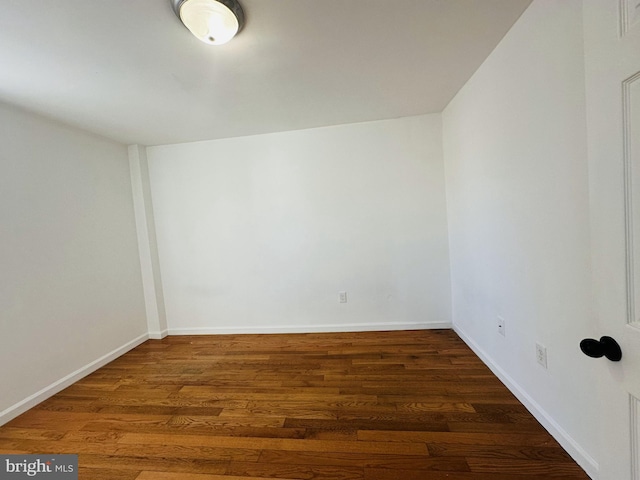 unfurnished room with baseboards and wood finished floors