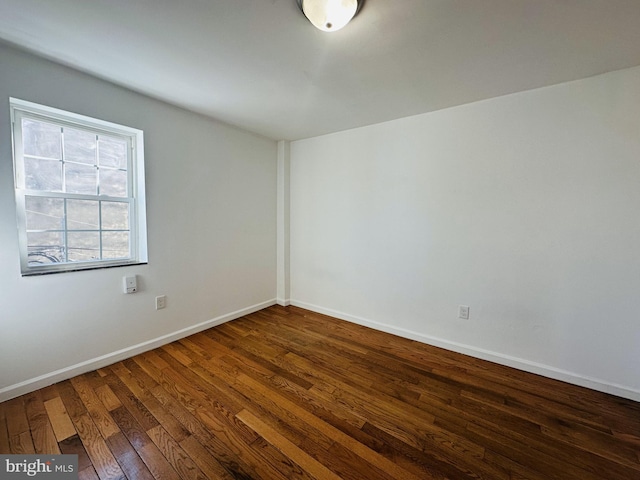 unfurnished room featuring baseboards and wood finished floors