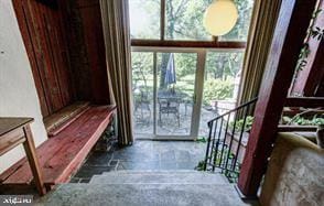 stairway featuring stone finish floor and a wall of windows