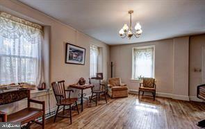 sitting room featuring baseboards, a notable chandelier, and wood finished floors