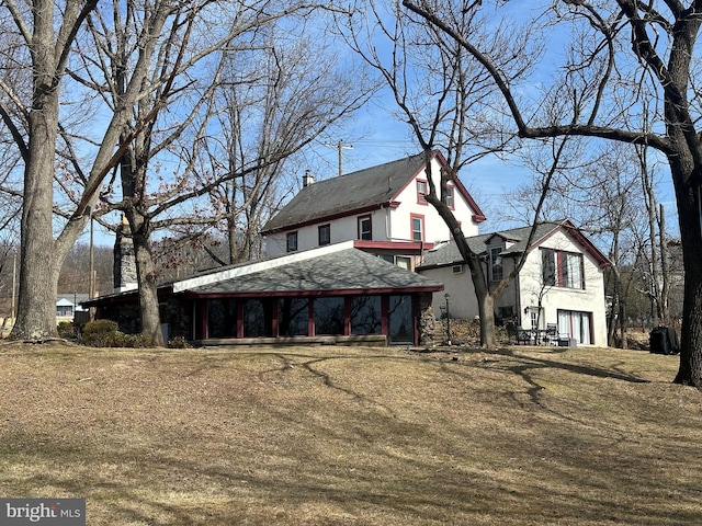 exterior space with stucco siding and a chimney