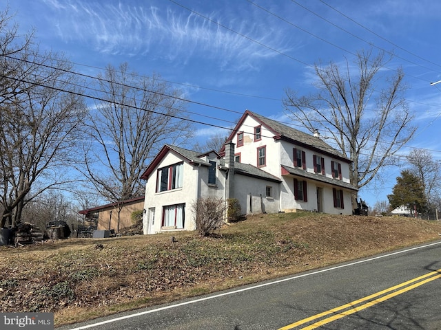 view of side of home with stucco siding and a chimney