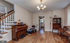 interior space with stairway, an inviting chandelier, and wood finished floors