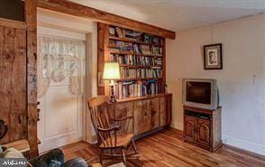 living area featuring baseboards and wood finished floors