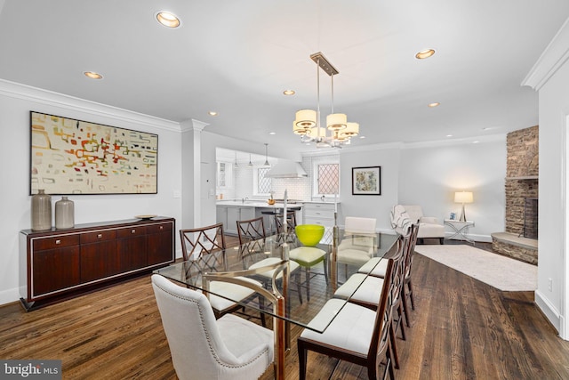 dining space with ornamental molding, recessed lighting, baseboards, a chandelier, and dark wood-style flooring