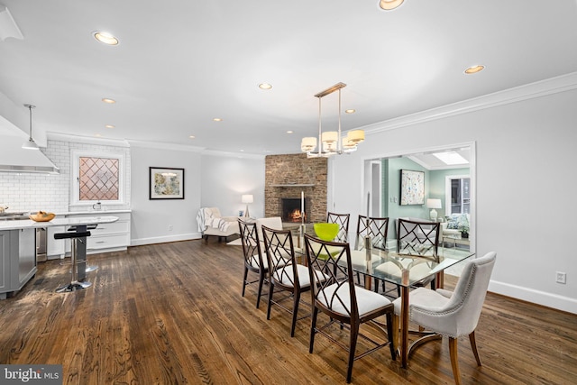 dining room with a fireplace, dark wood-style floors, and crown molding