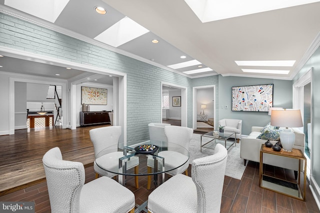 dining area featuring wood finish floors, brick wall, and crown molding